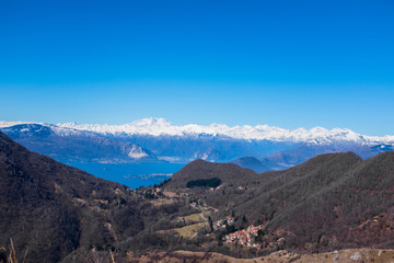 Fototapeta na wymiar panorama on the Alps and Lake Maggiore from the Lombard pre-Alps, valley of woods and small villages