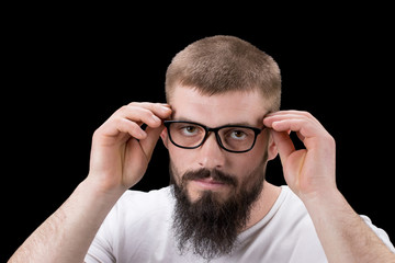 Cheerful smiling young businessman touching his glasses