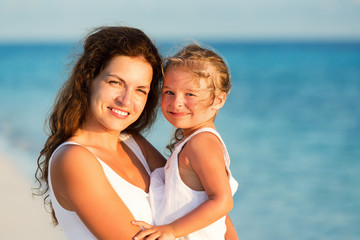 Fototapeta na wymiar Portrait of happy mother and little daughter on sunny beach