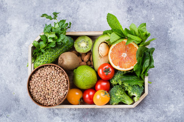 Healthy Food Clean Concept. Raw fruits, Vegetables, Nuts, Cereals in wooden Tray on Concrete Stone Table Background.