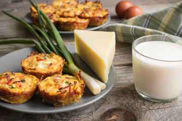 Muffins with scrambled eggs, cheese, bacon, potato and red pepper. Breakfast concept. Gray, rustic wooden background.