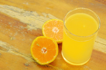orange juice in glass and tangerine cutting on wooden board
