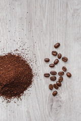 Coffee beans and ground powder on a wooden background