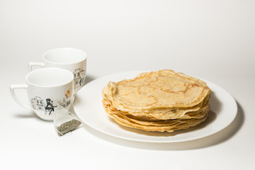 Isolated pancakes with cups of tea on white backgdound, pancakes on white plate