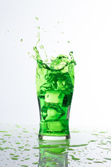 green water ice spalsh in a glass on white background