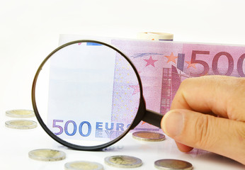 Checking 500 euro note with magnifying glass