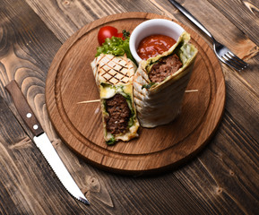 Burrito or tortilla served in restaurant or cafe. Minced meat