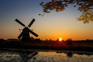 Autumn sunset on the Unesco world heritage site and windmill silhouette under a calm tree shade, Alblasserdam, Netherlands