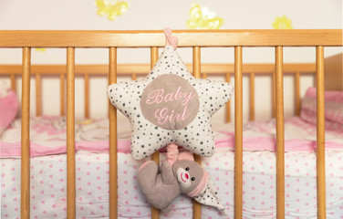 Newborns bed accessories. Sponge cushion in star shape attached from a newborn wooden bed.