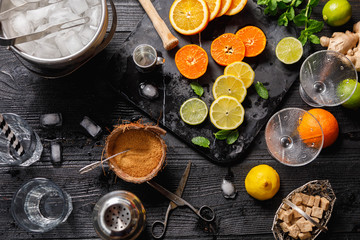 Cocktails ingredients with coconut sugar in coconut shell, Metal ice bucket, old scissors on marble board on black rustic table, Mojito, alcoholic, non-alcoholic drink-beverage. Top view, copy space