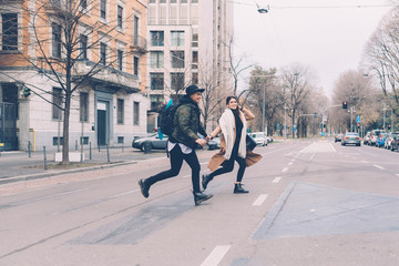 two women lesbian couple outdoors running hand in hand - late, hurry, couple concept