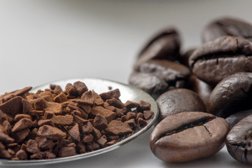instant coffee in metal spoon compare with coffee beans