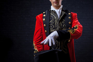 Magician. Close-up of hand in gloves The guy in the red camisole and the cylinder.