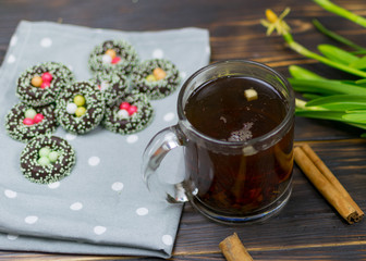A cup with herbal tea and cookies on a dark background.