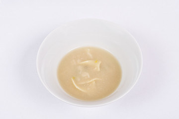 Cauliflower soup with noodles on a white