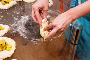The woman in the kitchen completes the molding of the pie.
