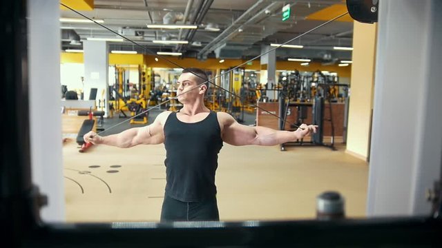 Strong muscular man at weight training in a gym
