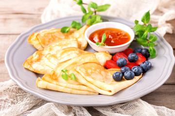Pancakes with jam and berries on a table. Selective focus.  Copy space.