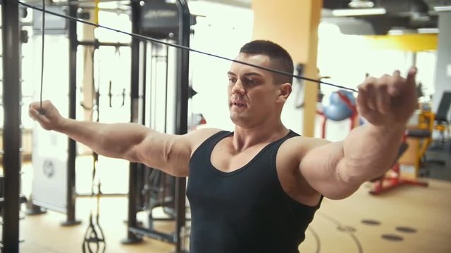 Strong bodybuilder exercising at the bright gym
