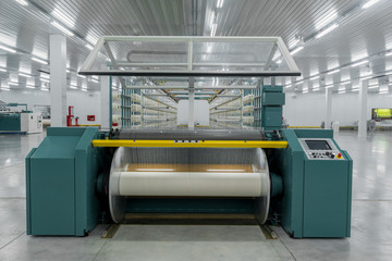 textile yarn on the wrapping machine is screwed on the big shaft. machinery and equipment in a...