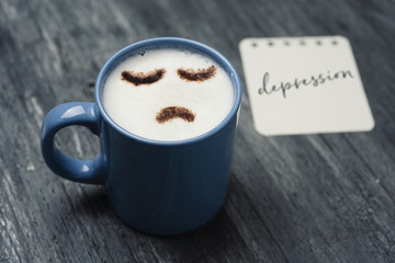 cup of cappuccino with a sad face.