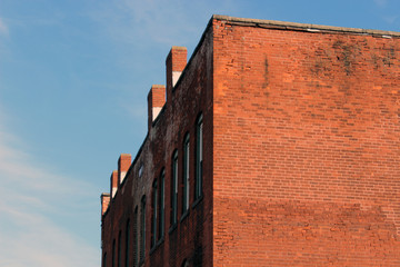 Fototapeta na wymiar Boarded up windows on abandoned industrial urban brick factory building 