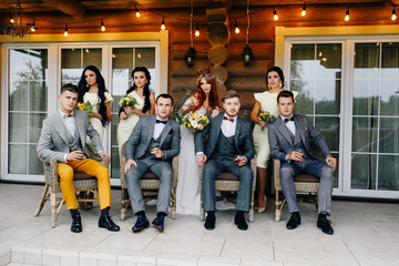 newlyweds with guests are on the terrace of the house