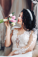 young bride brunette in the morning at home admiring her bouquet of flowers