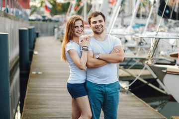 a young couple in shorts and white T-shirts hugging in the city in the summer