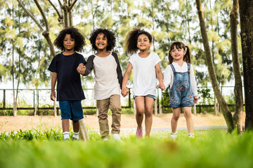 Group of children having fun playing together. Kids holding hands and walking in a park.