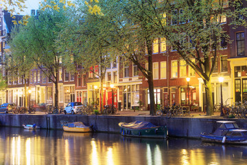 Fototapeta na wymiar Canals of Amsterdam. Moody night view of red light district