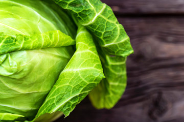 Green fresh cabbage head on wooden surface