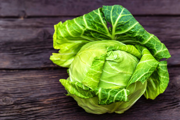 Green fresh cabbage head on wooden surface