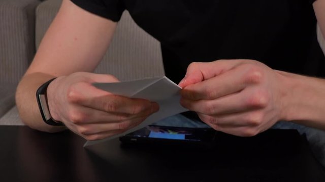 An artist makes origami in a living room - closeup