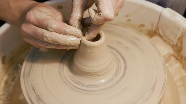 Handicraftsman create product on the circle potterswheel close up isolated. Artisan dexterity and skilfully sculpt traditional culture brown vase or cup. The creativity leisure, creating job of artist