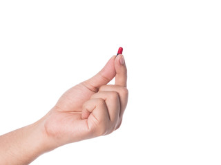 Hand holding a capsule or pill isolated on white.