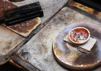 Fototapeta na wymiar The workplace of a jeweller. In the bowl are pieces of gold for smelting.