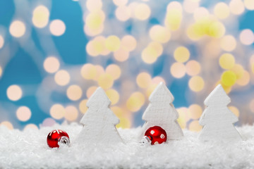 Kugeln und Tannenbäume im Schnee vor Bokeh 