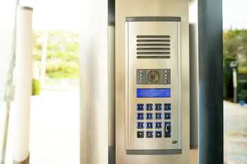 Close up of security system code device with numbered buttons on modern intercom device with blue...