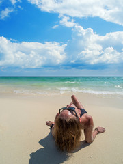 woman sunbathing lying down on the tropical beach