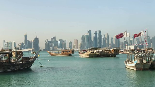 A Panoramic View of the Old Harbour in Doha, Qatar, with the West Bay Skyline in the Background. Modern Skyscrapers on Background and Old Boats Traditional on Foreground.