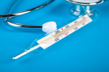 thermometer and phonendoscop on a blue background