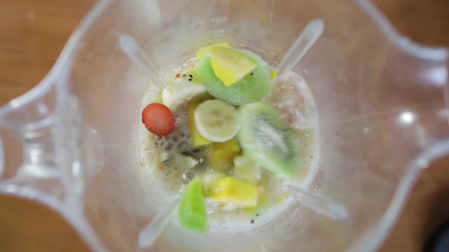 Frullato di frutta in partenza dentro un frullatore. Kiwi, fragole, banana e mango freschi.