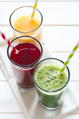 Detox drinks in glass: fresh smoothies from vegetables: beet, pumpkin and spinach on white background