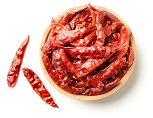 dried red chillies in the wooden plate, isolated on white, top view