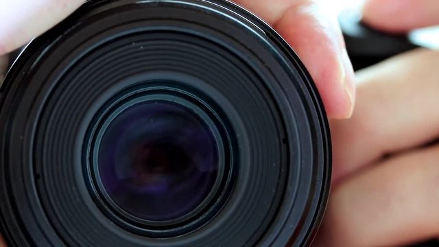 Detail of slow focus of the camera lens, front view. Gradually zooming the lens, close-up.
