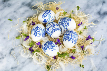 Fototapeta na wymiar Easter Eggs with Blue Painted Flowers on a Marble Background. Easter Decoration. Decoupage ideas .
