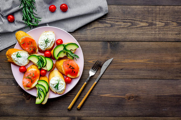 homemade sandwiches with french baguette, salmon, cheese and vegetable on wooden background top view mock-up