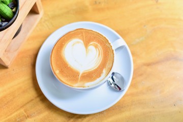 Top View of Cup of Coffee with Latte Art Heart Isolated on Wooden Table