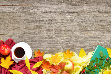Autumn set of red, green and yellow leaves, apples with cup of coffee or tea with books on vintage background.